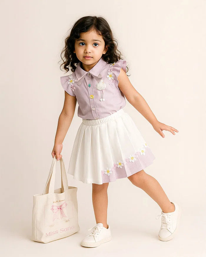 Young girl in a light purple shirt and white skirt with floral patterns, holding a white bag.