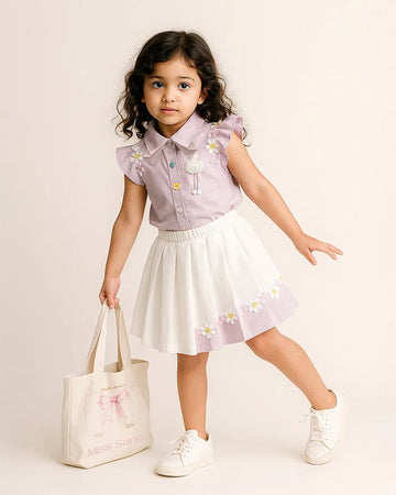 Young girl in a light purple shirt and white skirt with floral patterns, holding a white bag.
